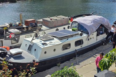 Jonge Jan with solar panel and tarp on riverbank